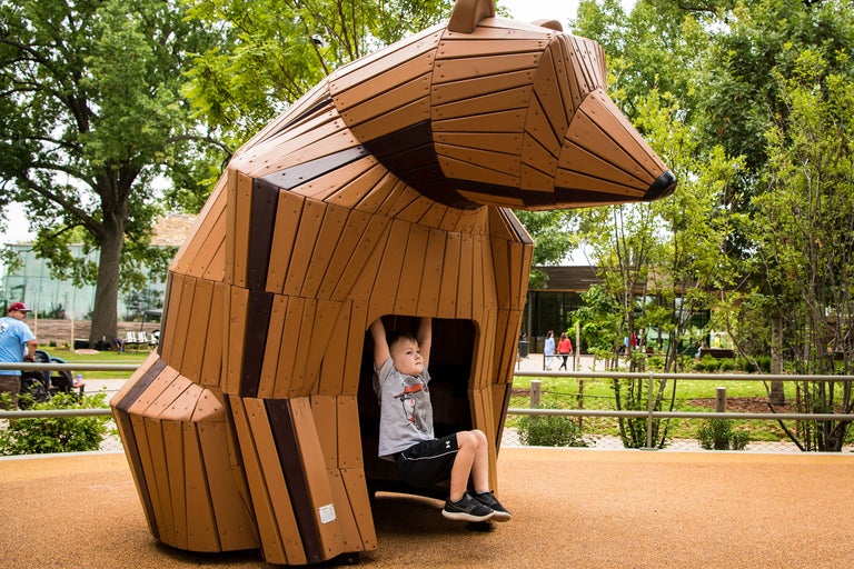 Junge spielt auf einem Bärenspielplatz aus Holz