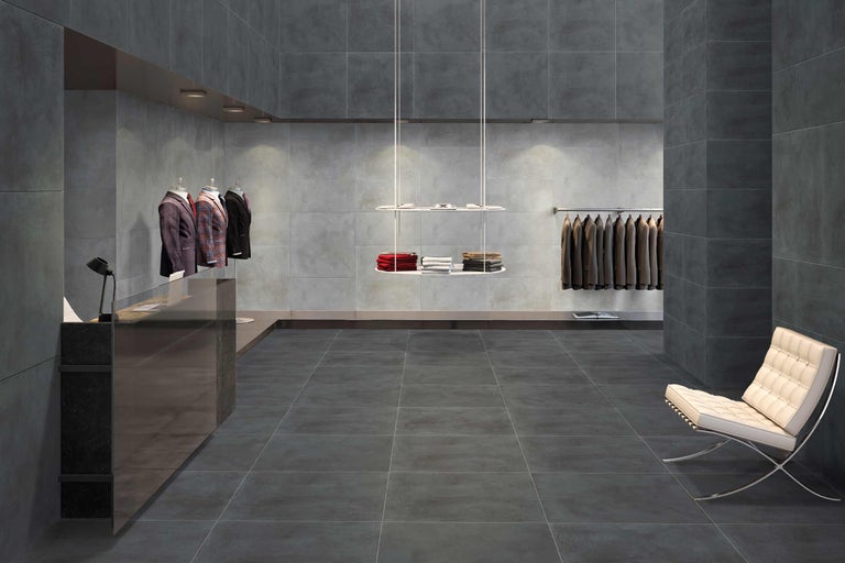 Boutique-Interieur mit Bodenfliesen, Wandfliesen, Kleidern und Sitzgelegenheit