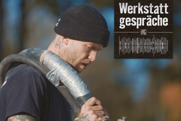 Werkstattgespräche Logo. Mann mit Mütze und Rohr auf der Schulter.