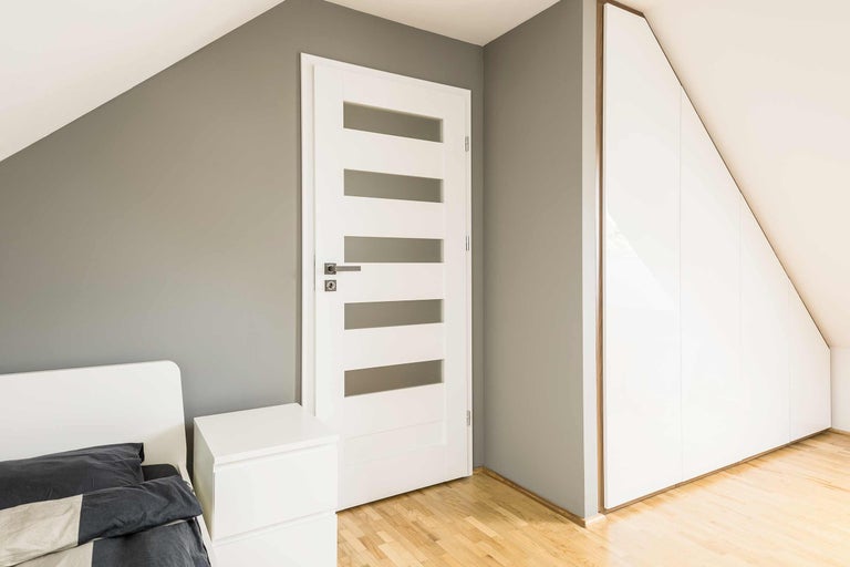 Modernes Schlafzimmer mit weißer Tür, Einbauschrank und Bett