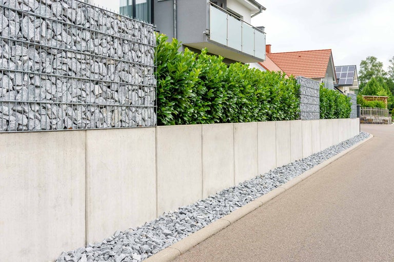 Gabionenwand kombiniert mit Betonelementen und Grünpflanzen als Sichtschutz im Garten