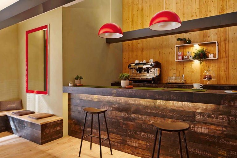 Innenraum mit Holzelementen, Kaffeemaschine und Sitzgelegenheiten