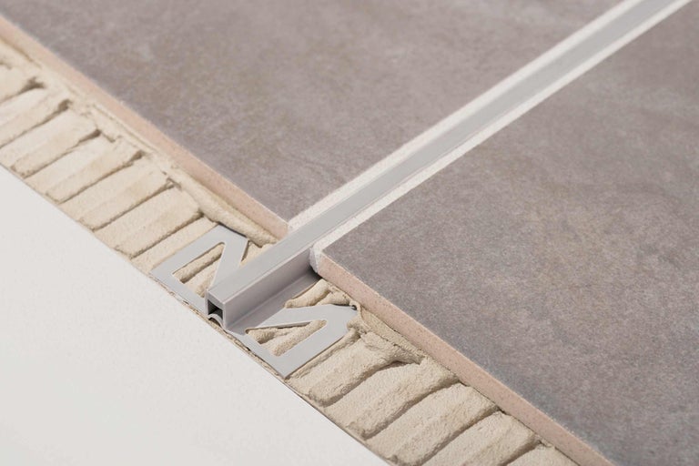 Detailansicht einer Fliesenschiene aus Metall zwischen zwei Fliesen