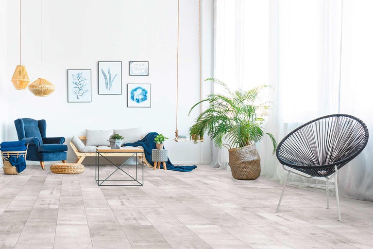 Heller Wohnraum mit Sessel, Sofa, Tisch und Vinylboden