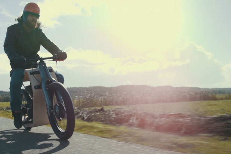 Ein Mann fährt ein Elektromotorrad auf einer Straße.