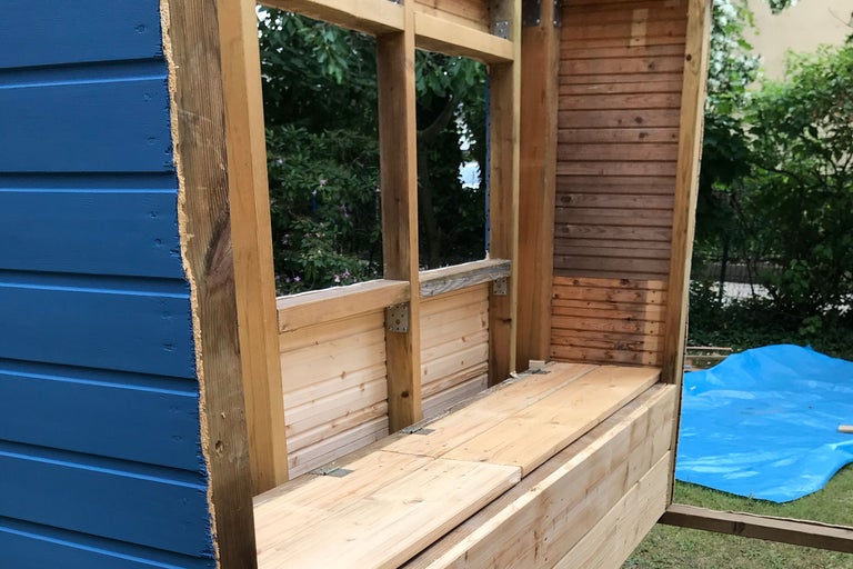 Holzhaus im Bau mit blau gestrichener Fassade und Fenstern