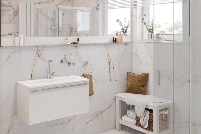 Helles Badezimmer mit Waschtisch, Spiegel, Handtuchhalter und Sitzbank vor Marmorwand