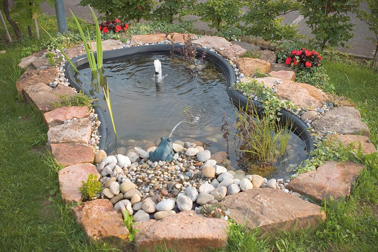 Gartenteich mit Steinen, Pflanzen und Teichfigur