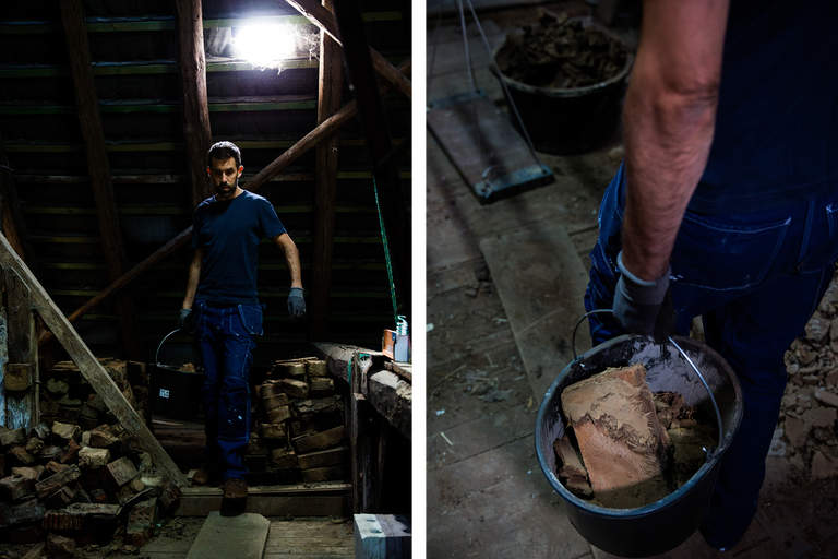 Mann mit Eimer voller Steine auf einem Dachboden.