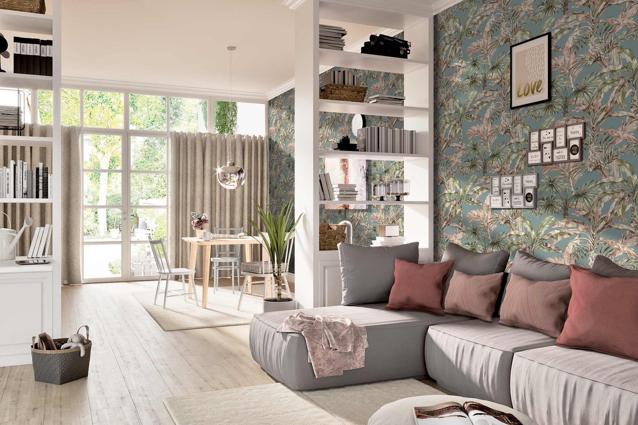 Heller Wohnraum mit Sofa, Regal, Esstisch und tropischer Tapete