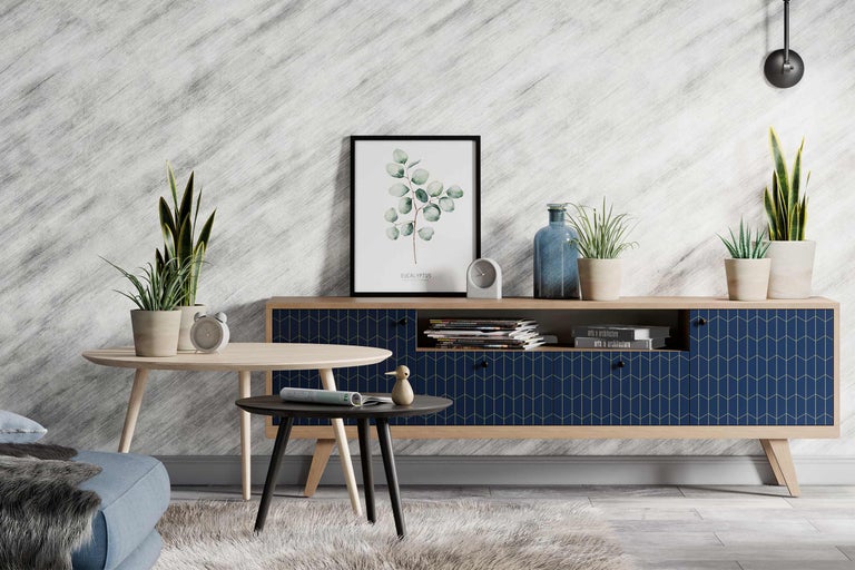 Wohnzimmer mit Kommode, Couchtischen und Zimmerpflanzen