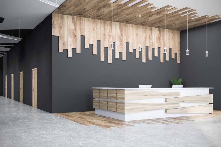 Holzverkleidete Bürolobby mit Empfangstresen und Pendelleuchten.