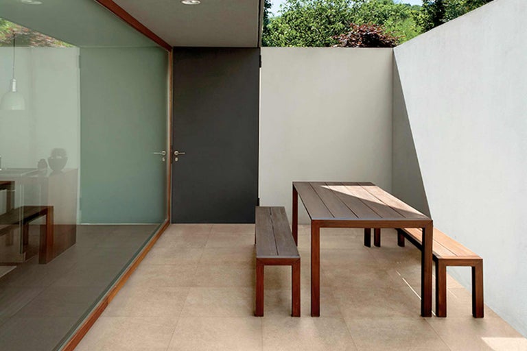 Außenbereich mit Holztisch und Holzbänken auf Fliesenboden