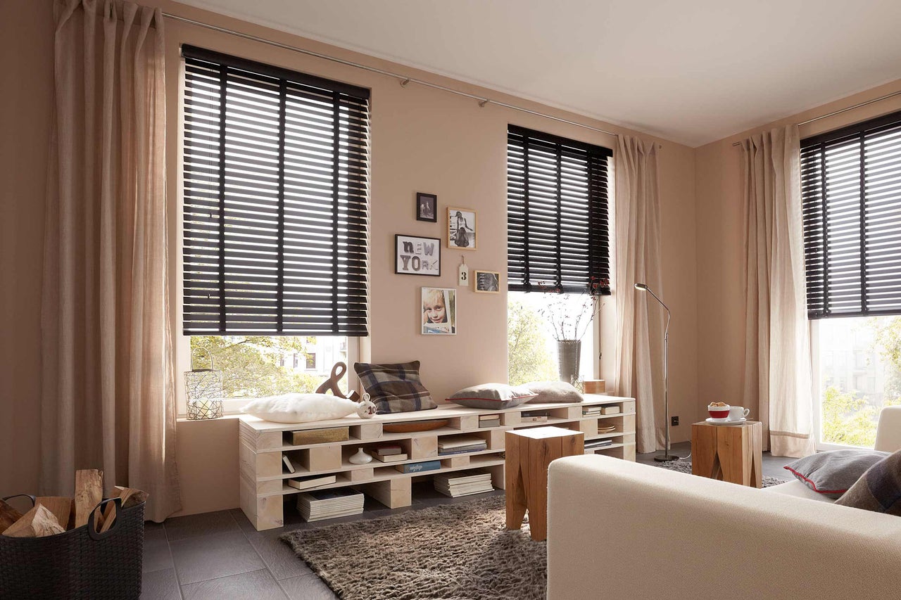 Wohnzimmer mit Fenster, Holzjalousien und Vorhängen für Sichtschutz und Dekoration