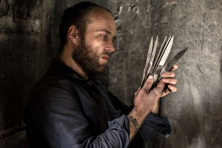 Mann betrachtet Gartenwerkzeug, Gartenschere