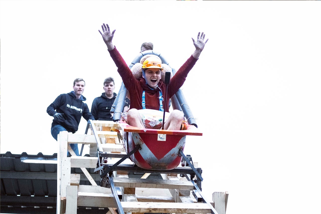 Mann mit Schutzhelm auf einer improvisierten Rodelbahn