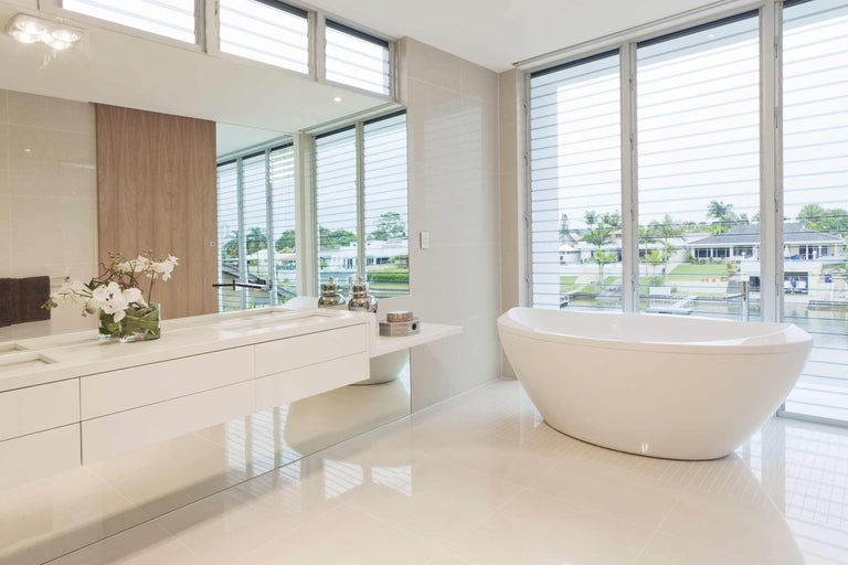 Helles Badezimmer mit Badewanne, Waschtisch und großem Spiegel