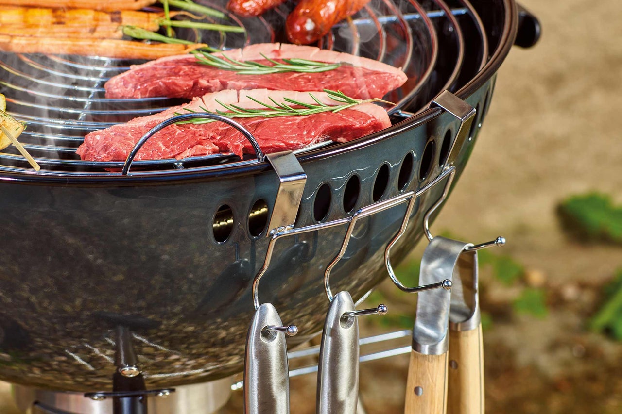Kugelgrill mit Grillgut und Grillwerkzeug