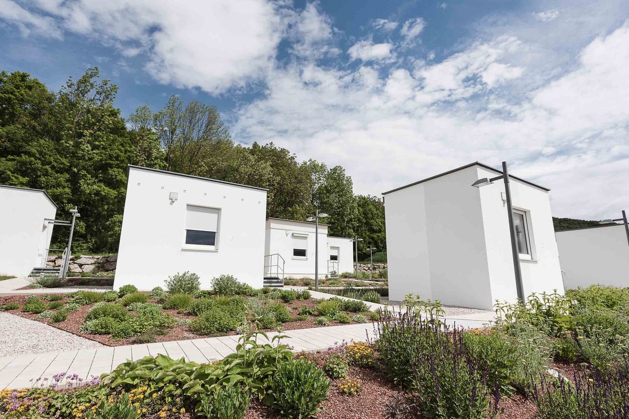 Mehrere weiße Modulhäuser mit Gartenanlage