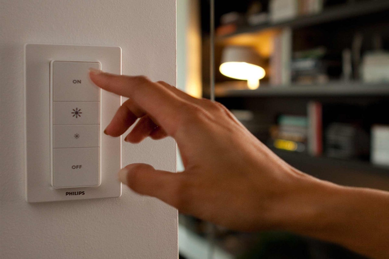Hand betätigt Philips Lichtschalter an der Wand
