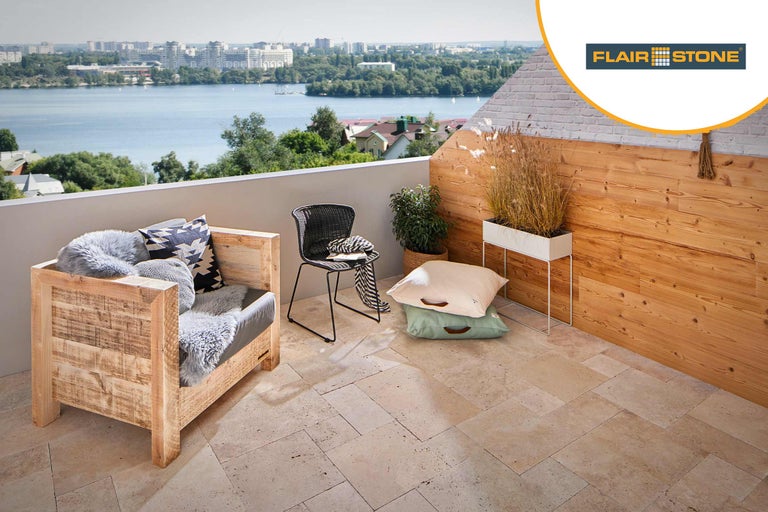 Heller Balkon mit Holzsessel, Stuhl, Pflanzen und Flair Stone Logo