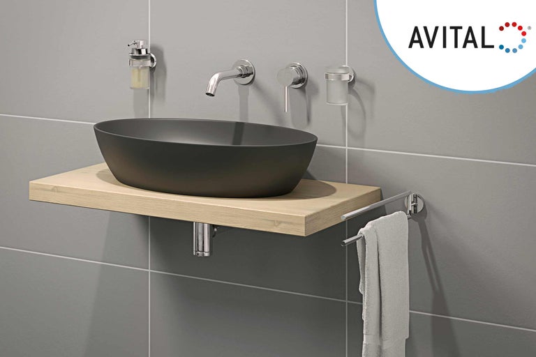 Modernes Badezimmer mit schwarzem Aufsatzwaschbecken auf hellem Holzregal, Armatur, Seifenspender, Zahnputzbecher und Handtuchhalter.
