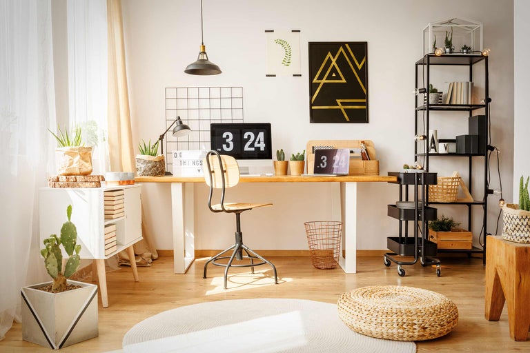 Helles Arbeitszimmer mit Schreibtisch, Stuhl, Regalen und Zimmerpflanzen für eine freundliche Atmosphäre.