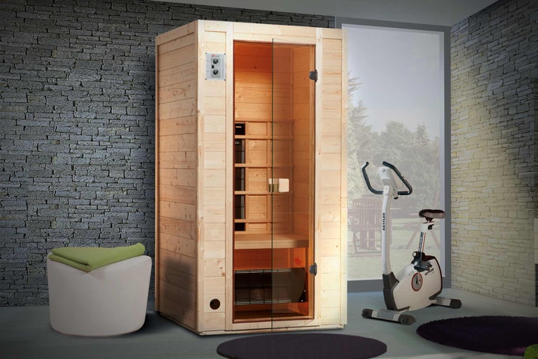 Innenraumansicht mit Holzsauna, Hocker mit Tuch und Heimtrainer.