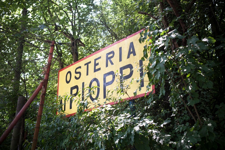 Osteria Pioppi Schild zwischen Bäumen