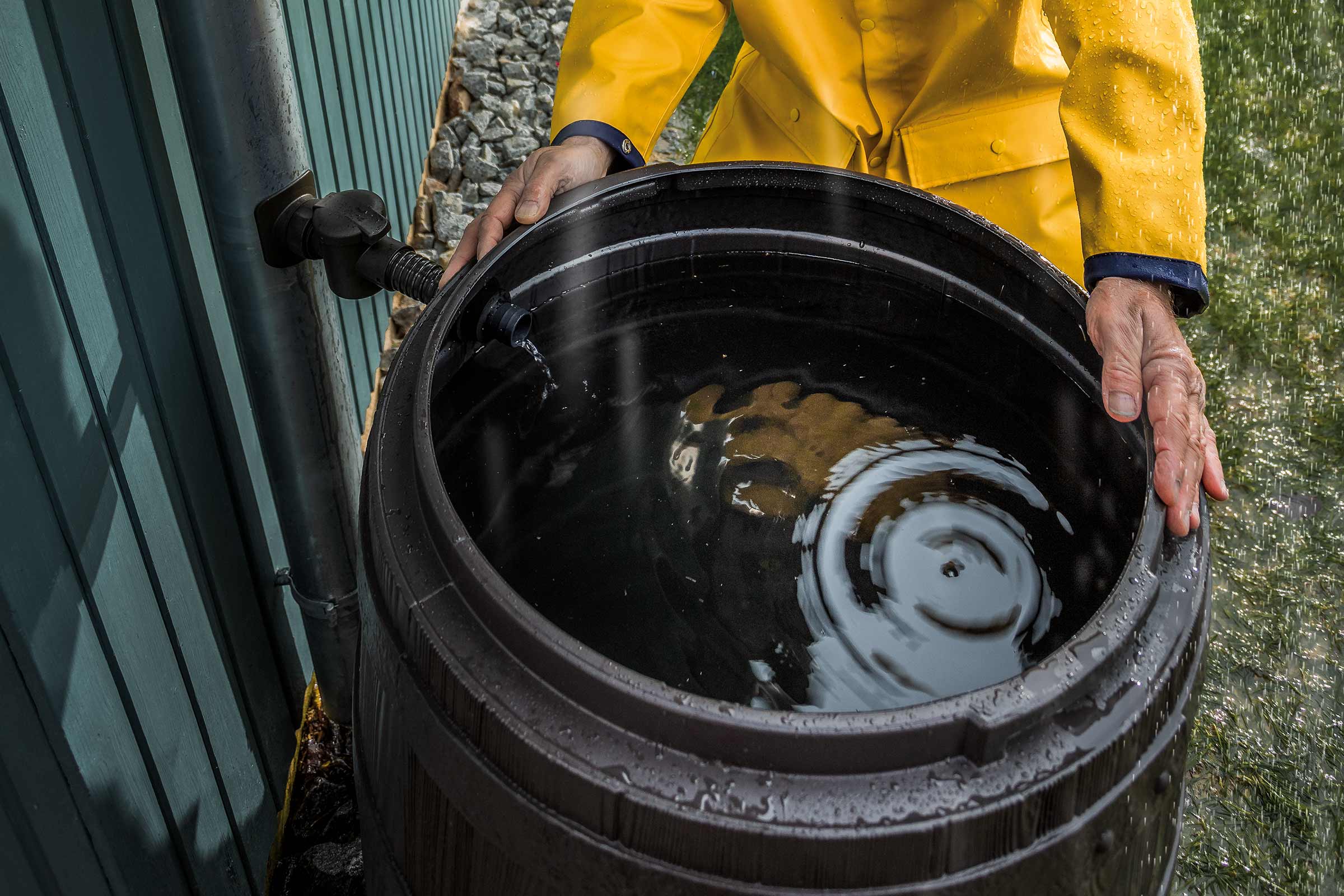 Regentonne wird mit Wasser befüllt