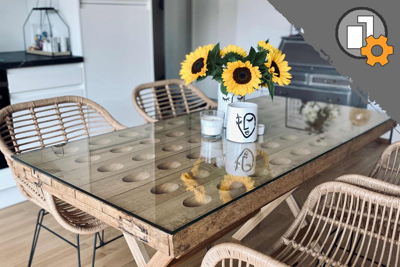 Esstisch mit Glasplatte, Holzelementen und Rattanstühlen