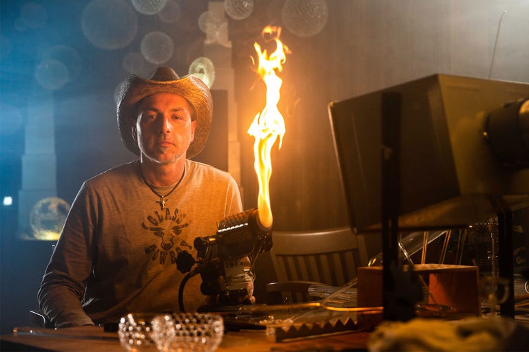 Mann mit Cowboyhut, der einen Brenner bedient, zur Glasbearbeitung.