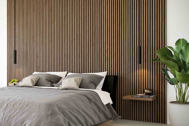 Schlafzimmer mit Akustikpaneelen an der Wand, Bett und Hängelampen.