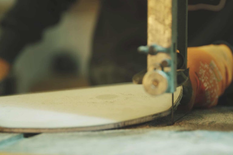 Nahaufnahme einer Bandsäge, die ein Werkstück schneidet.