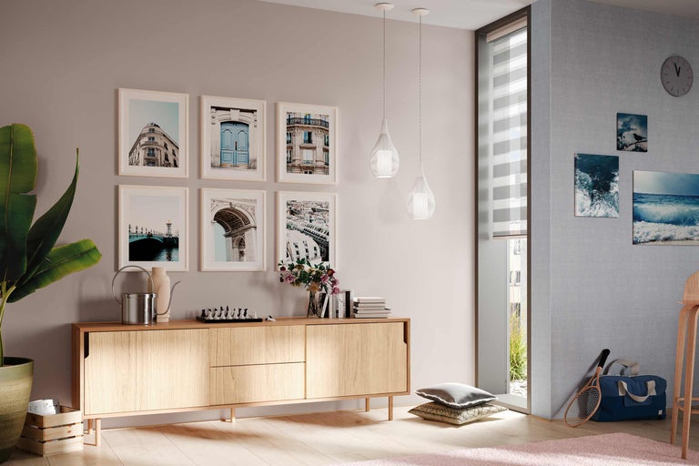 Wohnzimmer mit Holzkommode, Bildern, Pendelleuchten und Dekorationen für ein gemütliches Ambiente.