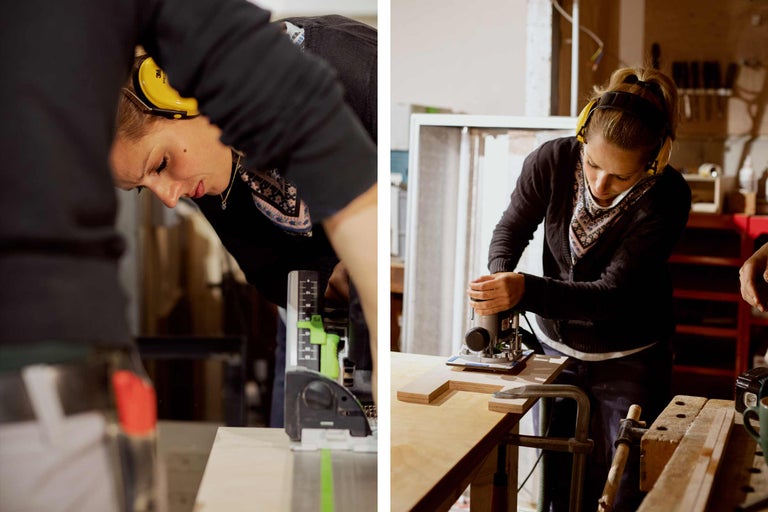 Frau arbeitet mit einer Oberfräse und Gehörschutz an einem Holzstück.