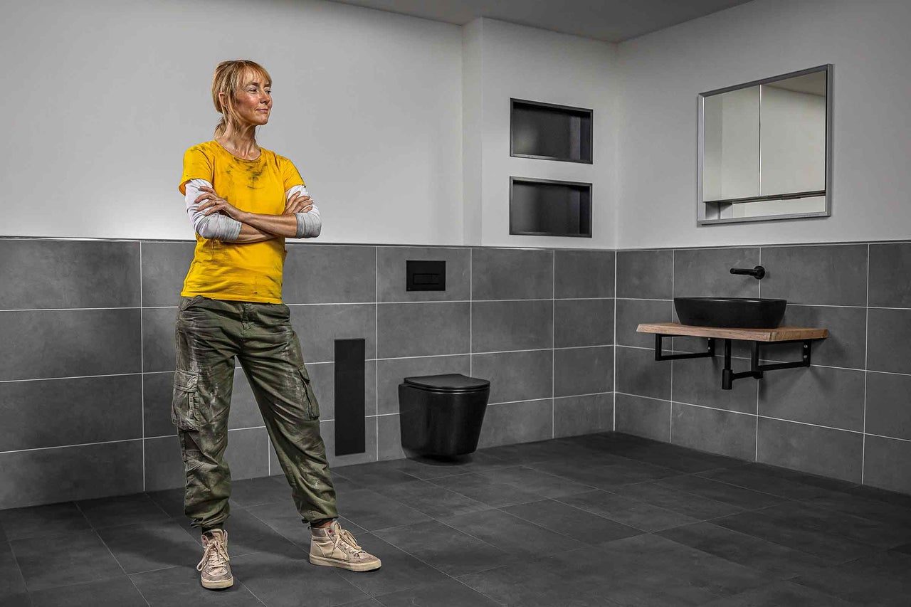 Modernes Badezimmer mit Fliesen, Toilette, Waschbecken und Installateur