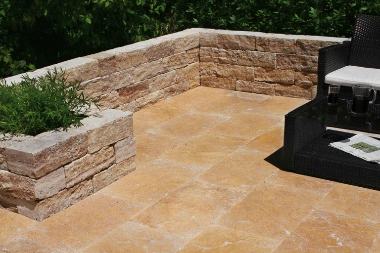 Terrasse mit Natursteinmauer, Bodenplatten und Sitzgruppe