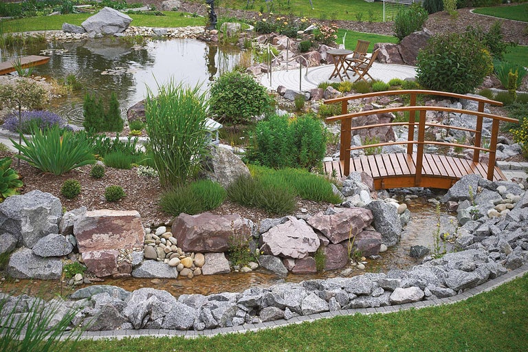 Gartenteich mit Holzbrücke, Steinen und Bepflanzung