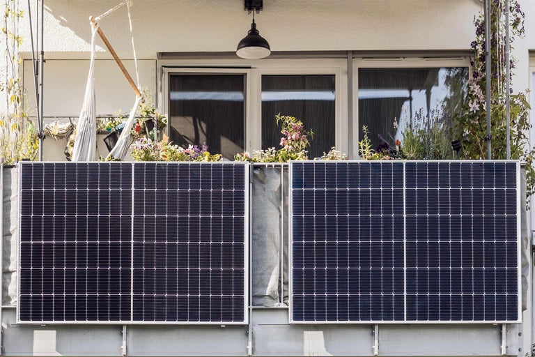 Balkon mit Solarmodulen und Pflanzenkästen