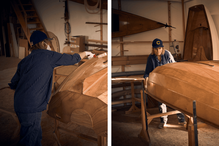 Zwei Personen arbeiten in einer Werkstatt an Holzbooten.