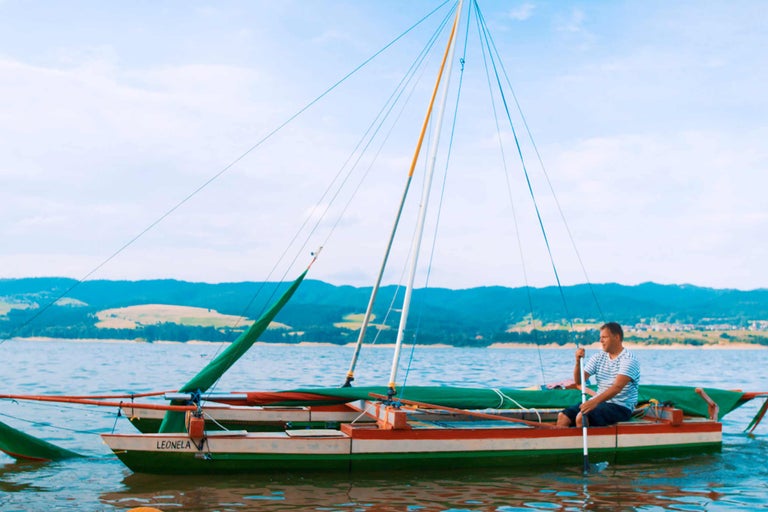 Mann rudert Boot auf dem See