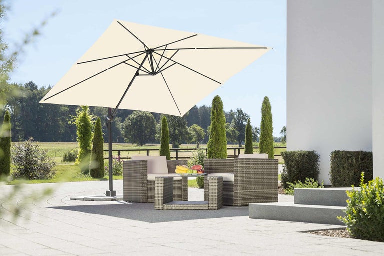 Quadratischer Sonnenschirm über Sitzgruppe im Freien