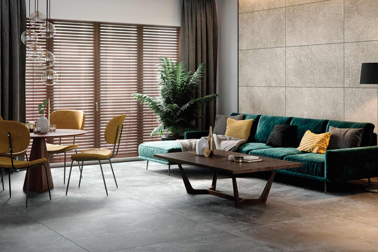 Wohnzimmer mit Sofa, Tisch, Stühlen, Bodenfliesen und Fensterjalousien