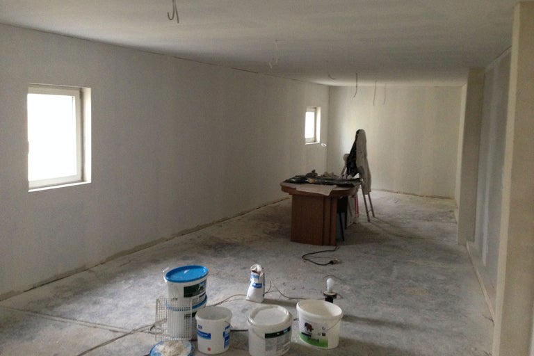 Heller Raum mit Farbeimern und Renovierungsbedarf