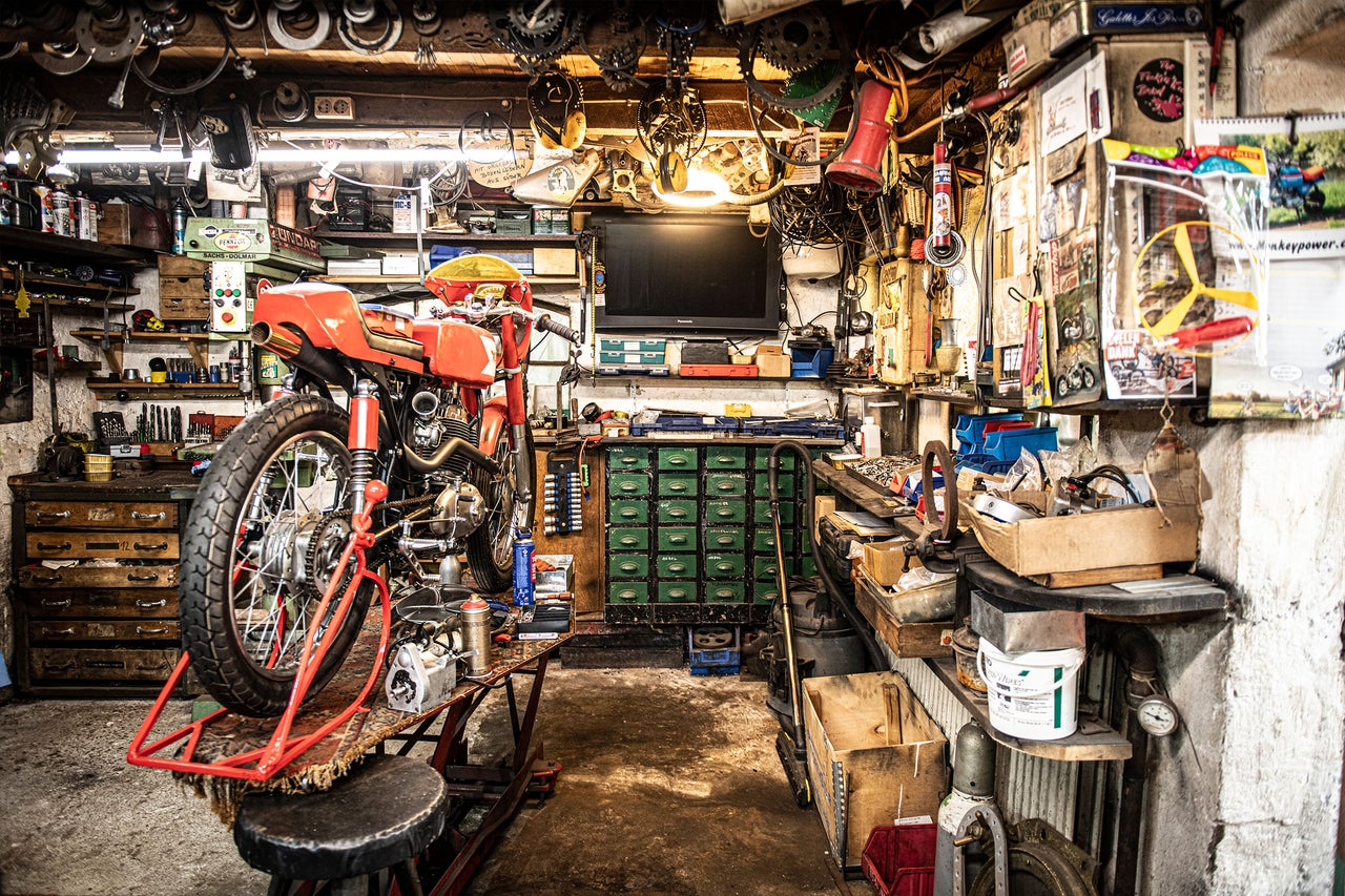 Werkstatt mit Motorrad auf Hebebühne, Werkzeug und Werkbank