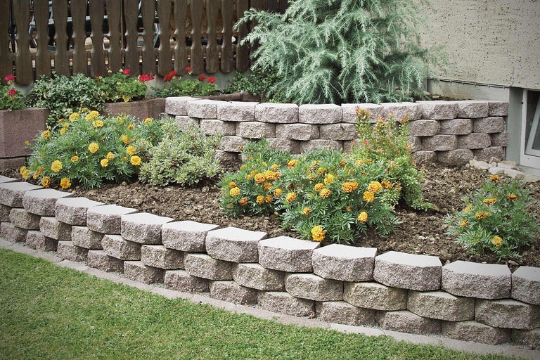 Gestufter Garten mit Pflastersteinen und Blumen