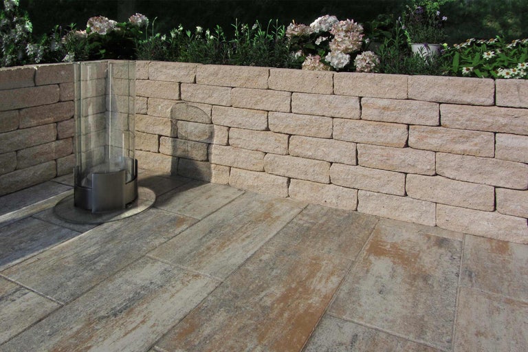 Gartenszene mit einer Steinmauer und Terrassenplatten