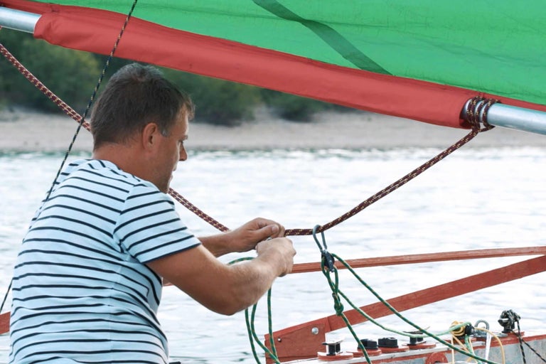 Mann befestigt Seil auf Segelboot