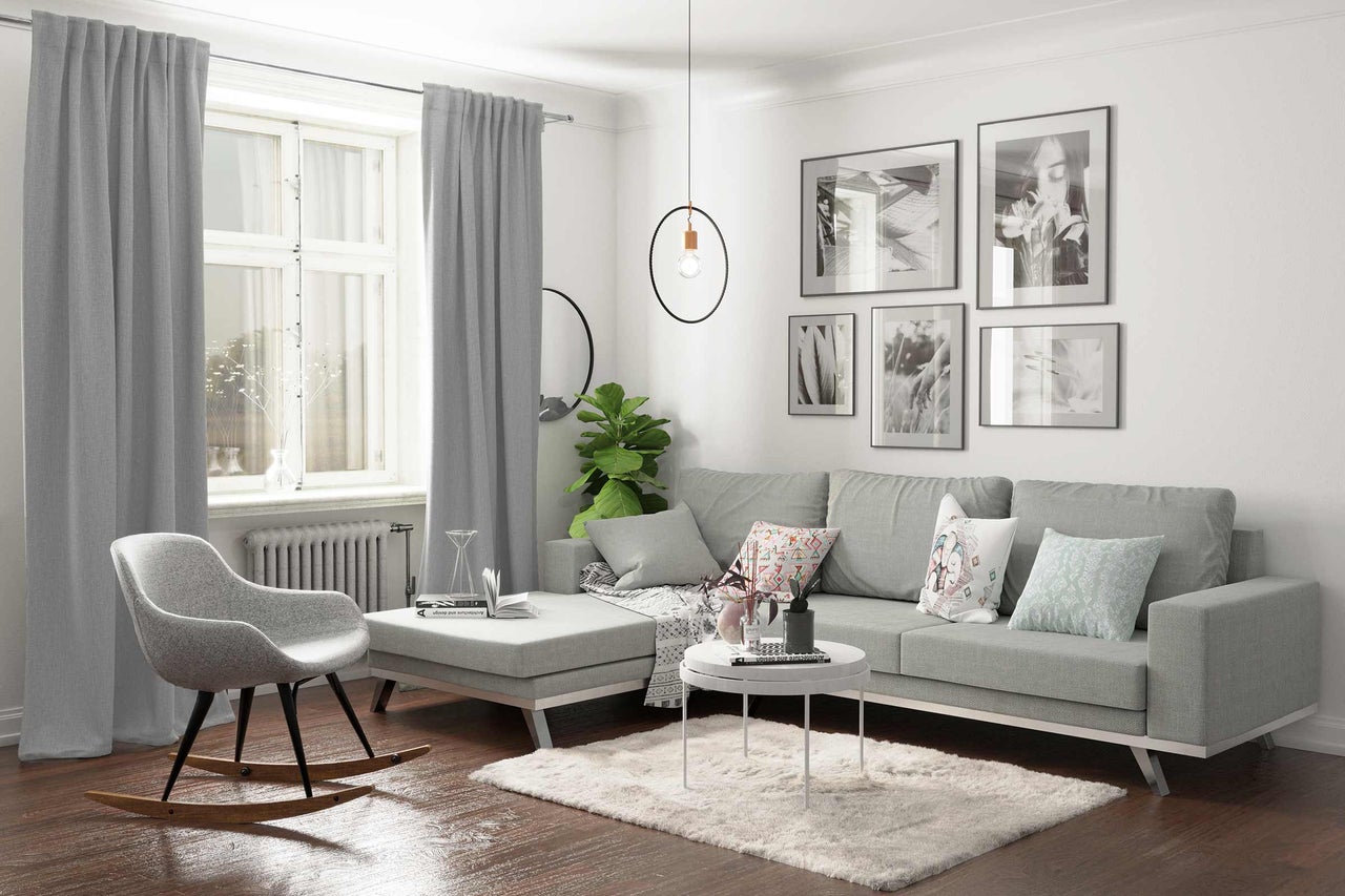 Wohnzimmer mit grauem Sofa, grauem Vorhang, Pendelleuchte und Dekoration